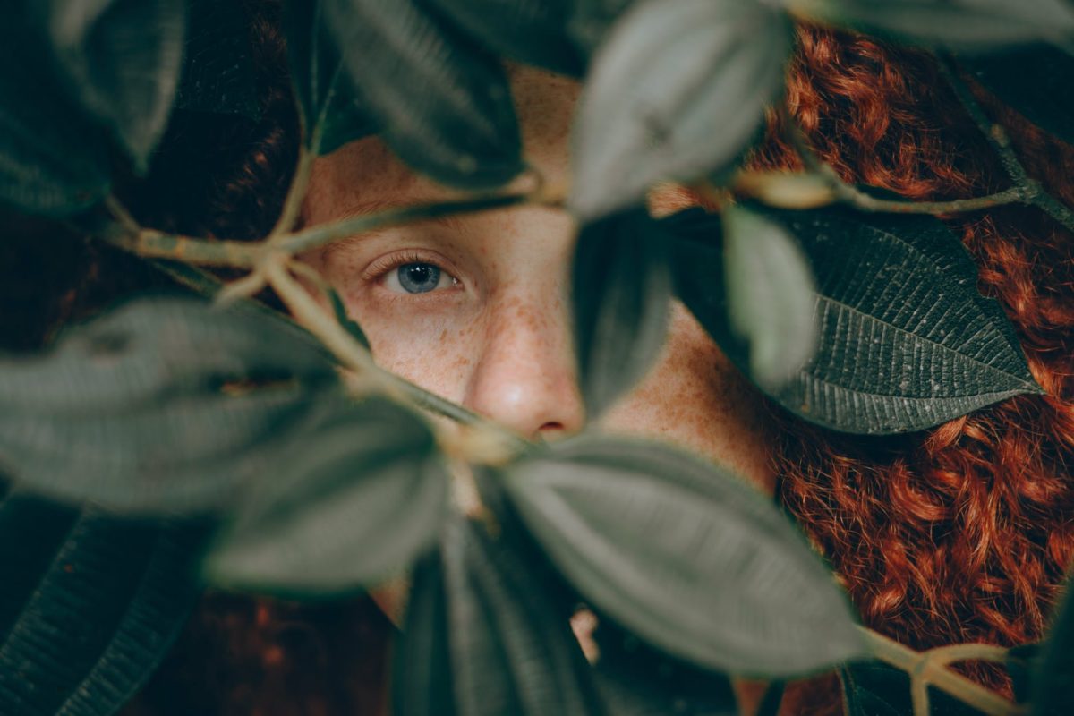 close up photo of person behind leaves