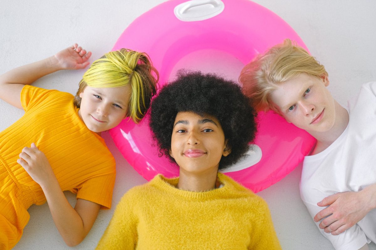 cheerful smiling diverse teenage friends on pink floater