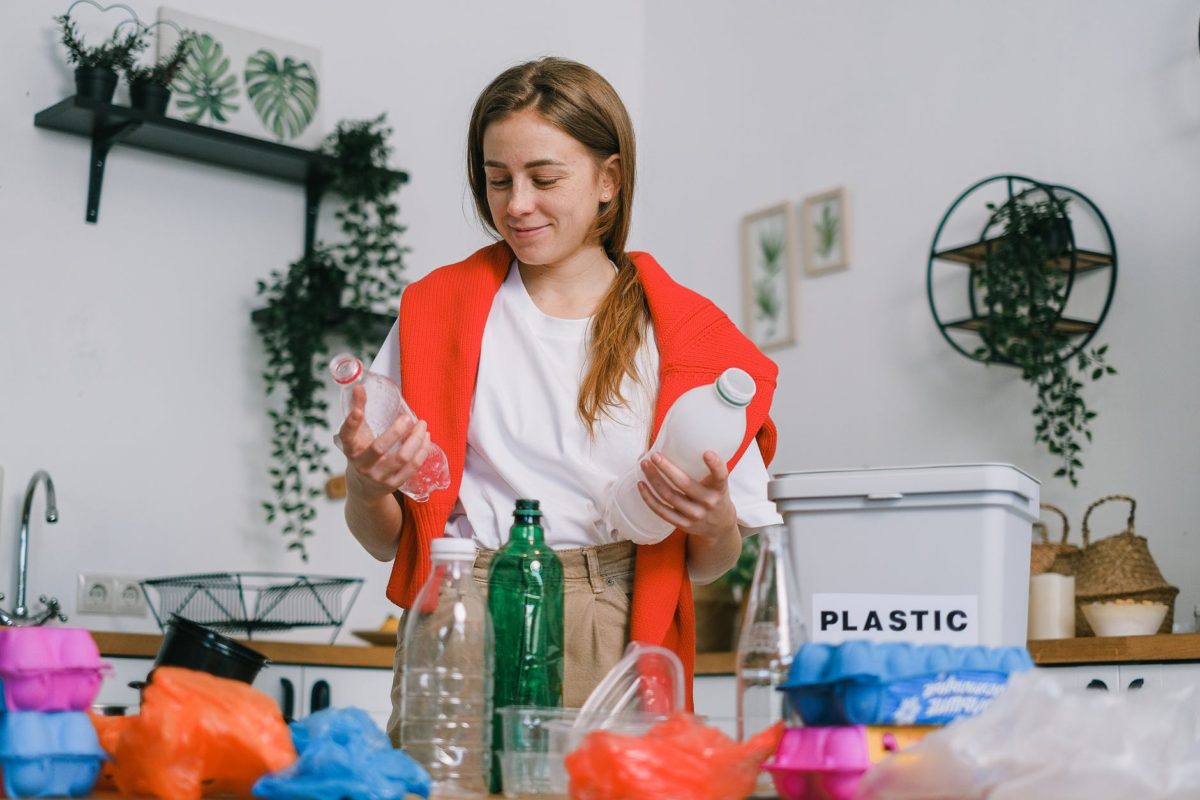 positive female sorting plastic bottles in kitchen in apartment